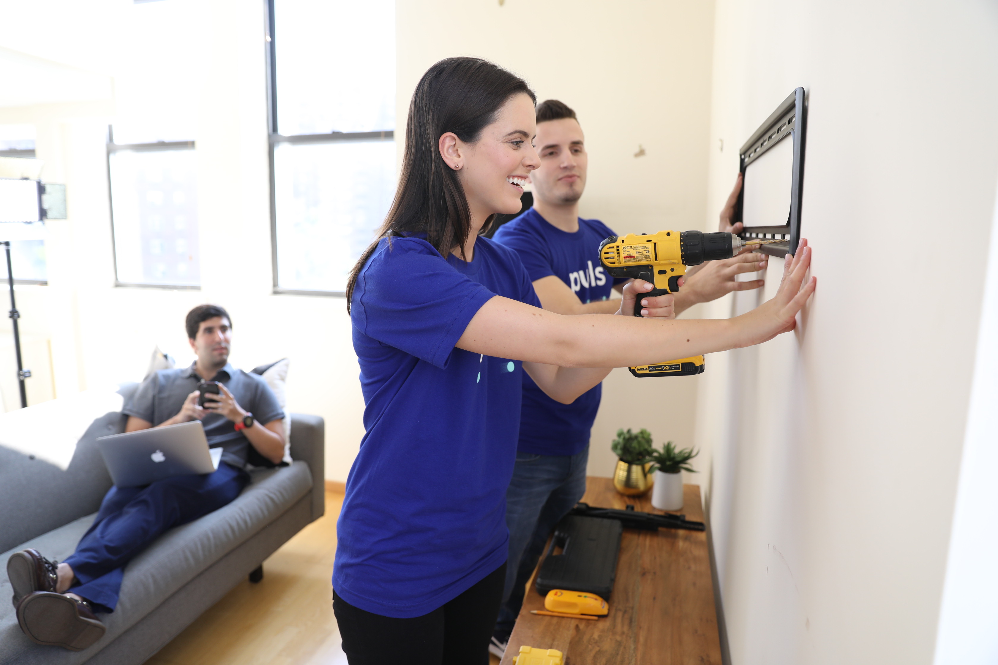 Puls technicians installing TV mount