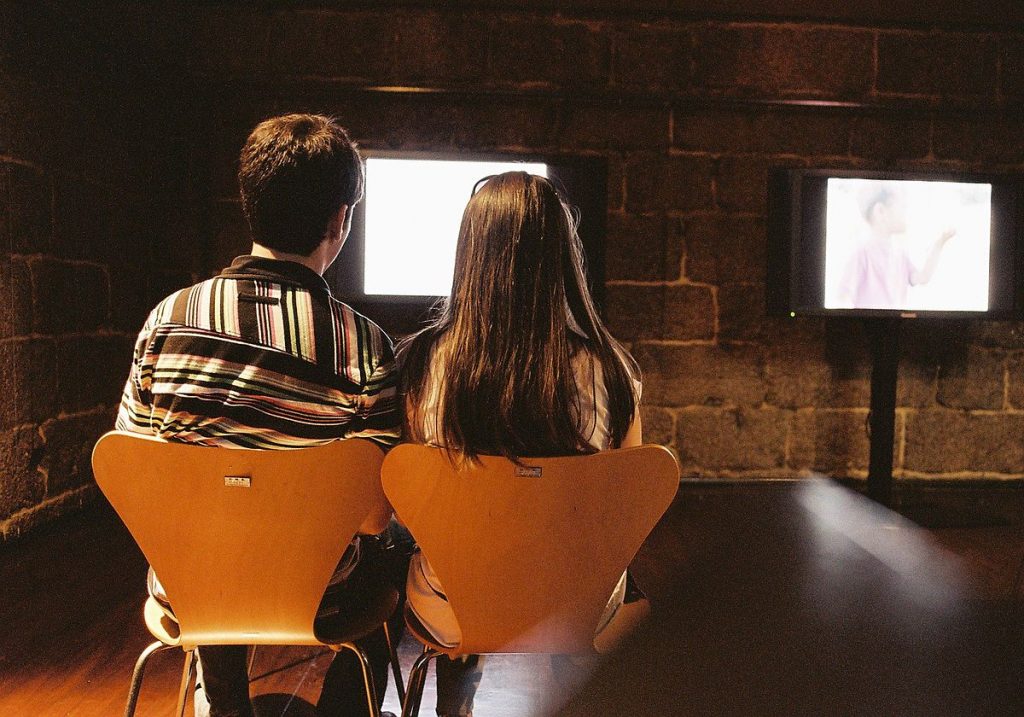 image of couple sitting in front of a tv
