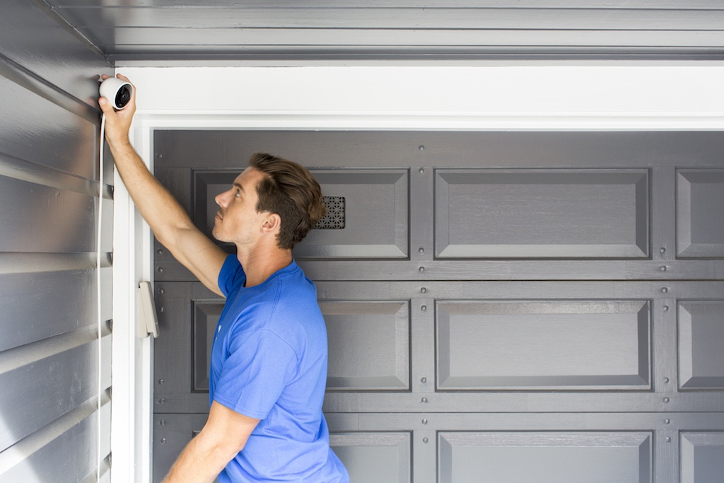 man installing nest security camera in gargage