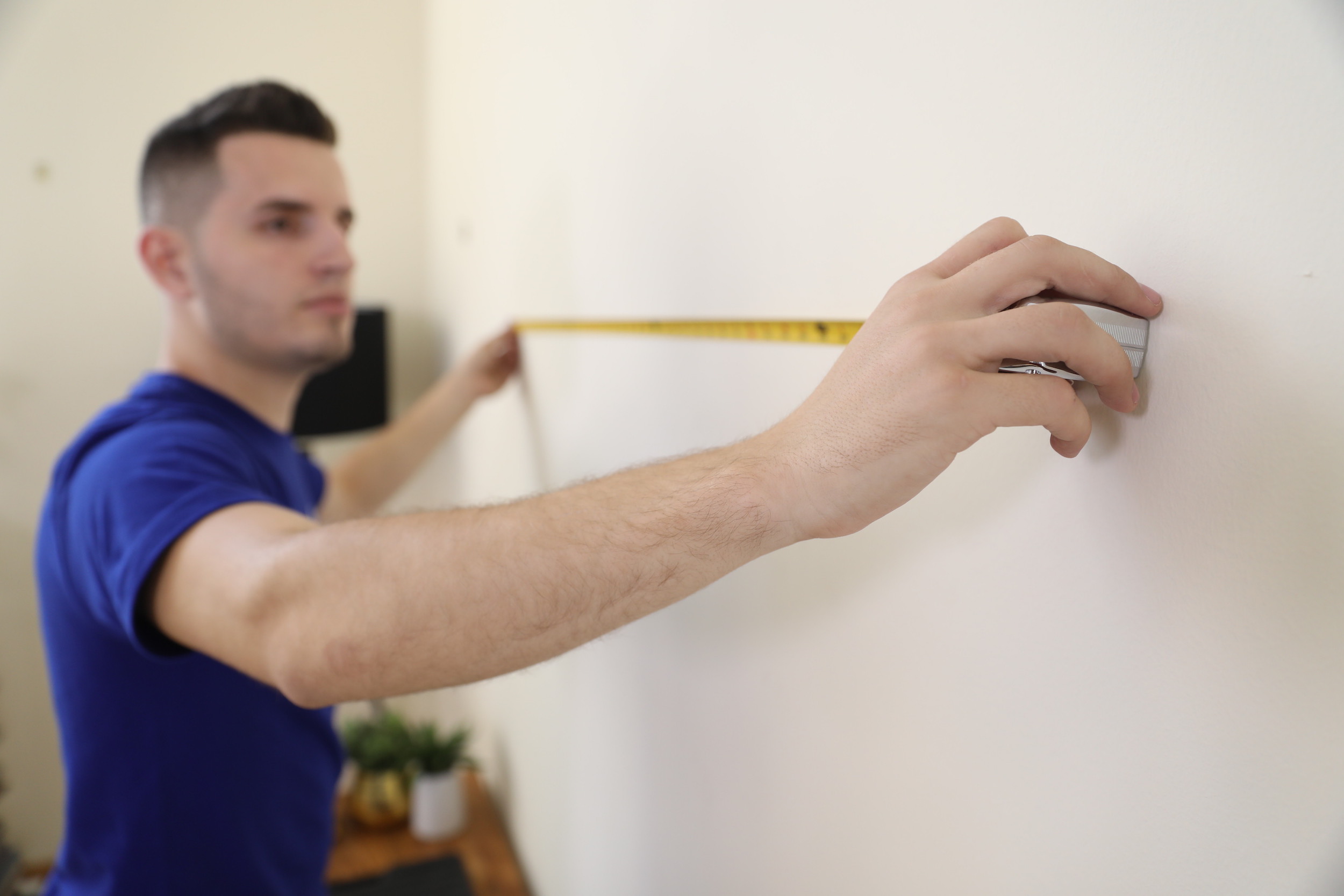 man measuring for tv wall mount