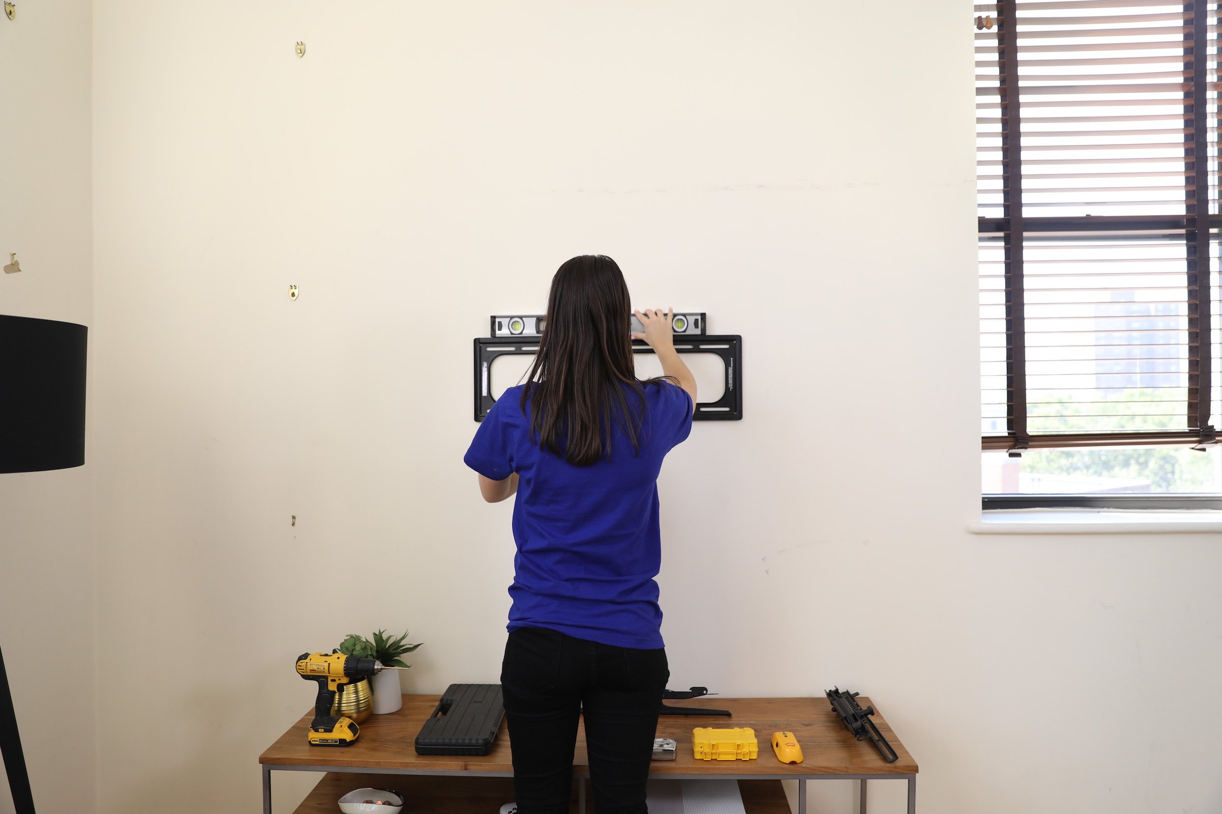 girl hanging tv mount on wall