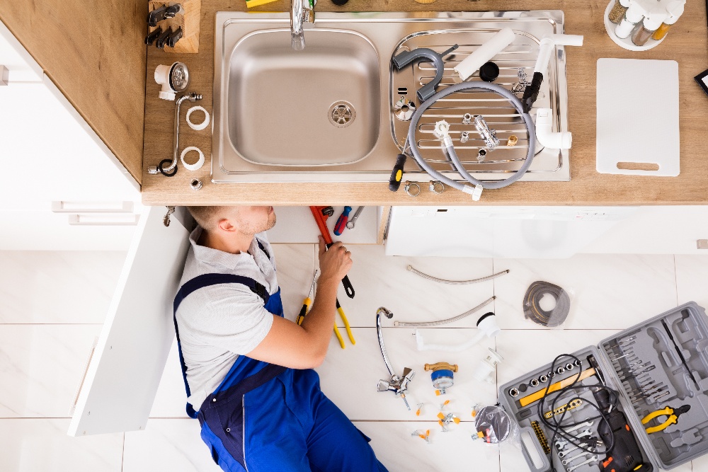 plumber fixing leaky sink